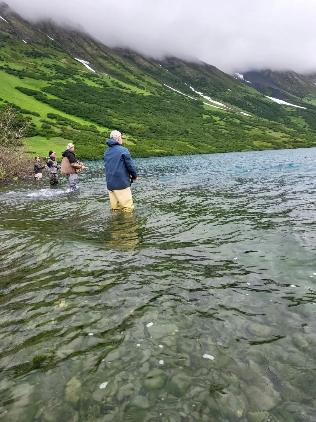 A group of people fishing in the water.