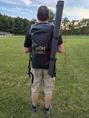 Person with backpack and roll tube outdoors.